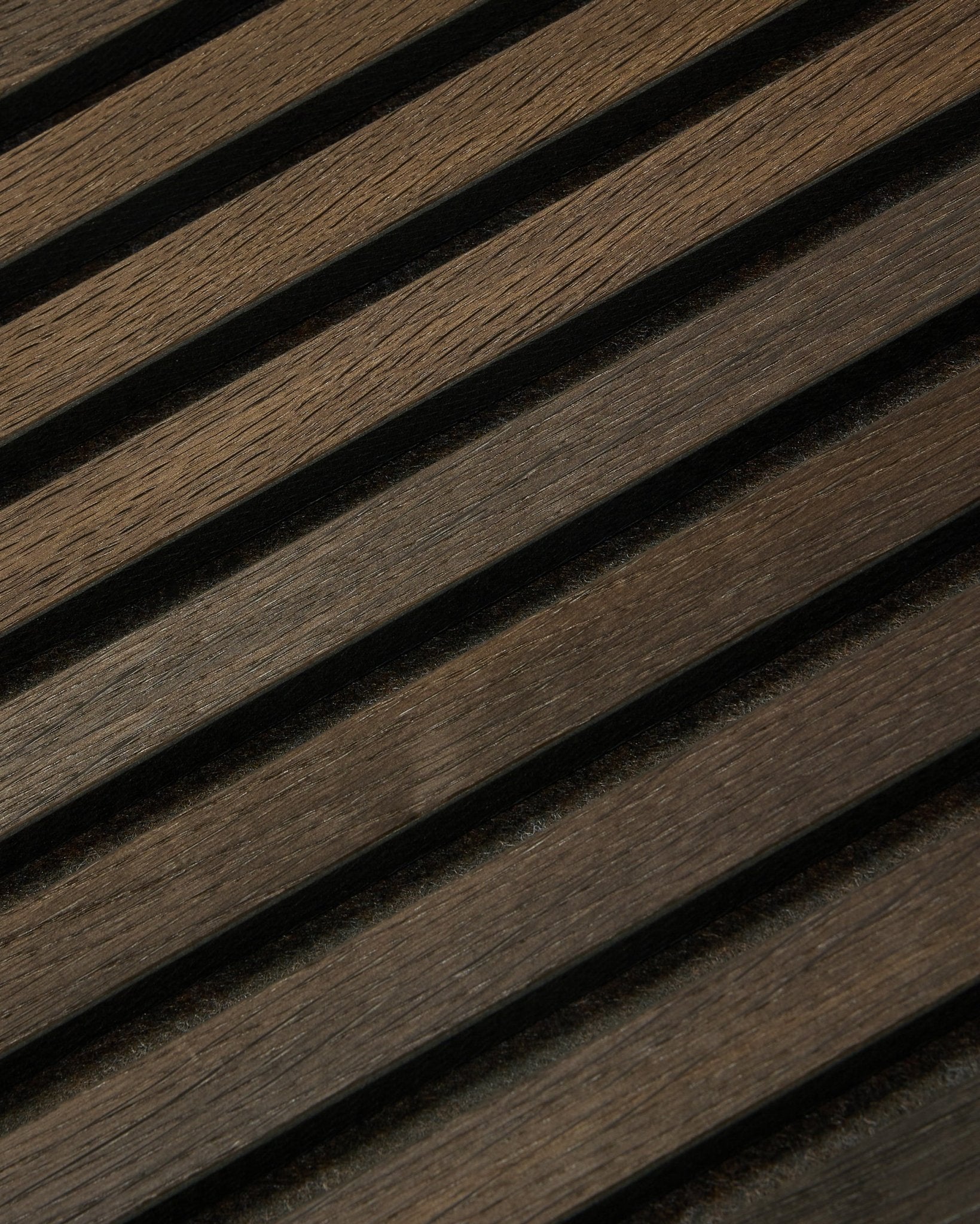 Close-up of Tonal Akupanel acoustic panel in Smoked Oak (240 x 60 cm) by WoodUpp, featuring diagonal, textured Nordic slats in a Scandinavian design.